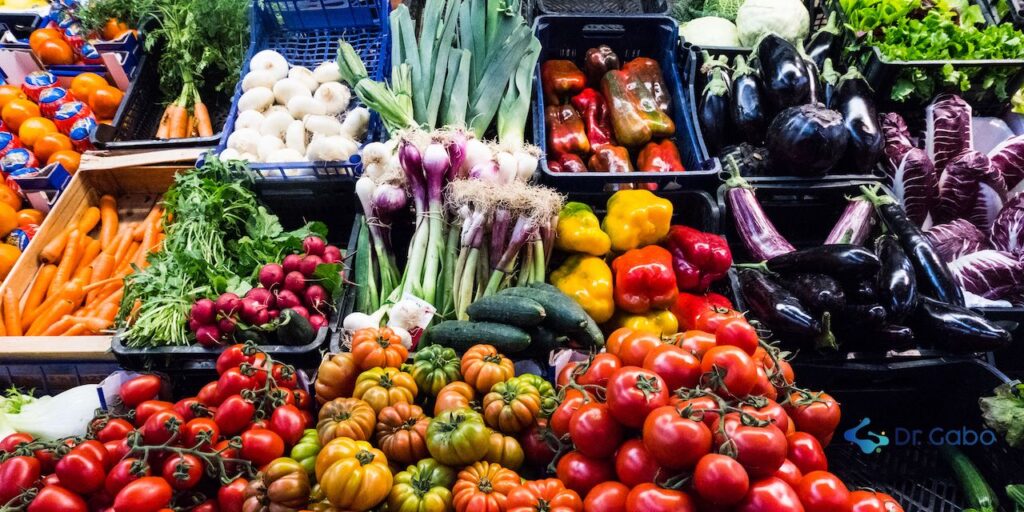 "Vibrante puesto de mercado rebosante de verduras de todos los colores, simbolizando la rica diversidad y la importancia de incorporar un arcoíris de nutrientes en nuestra dieta consciente para nutrir cuerpo, mente y espíritu."